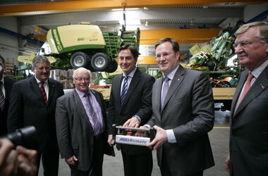 Crane operators of the company Krone control ABUS crane in front of one of their agricultural machines