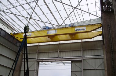 Crane with electric wire rope hoist in production hall where components for driver's cabs are manufactured