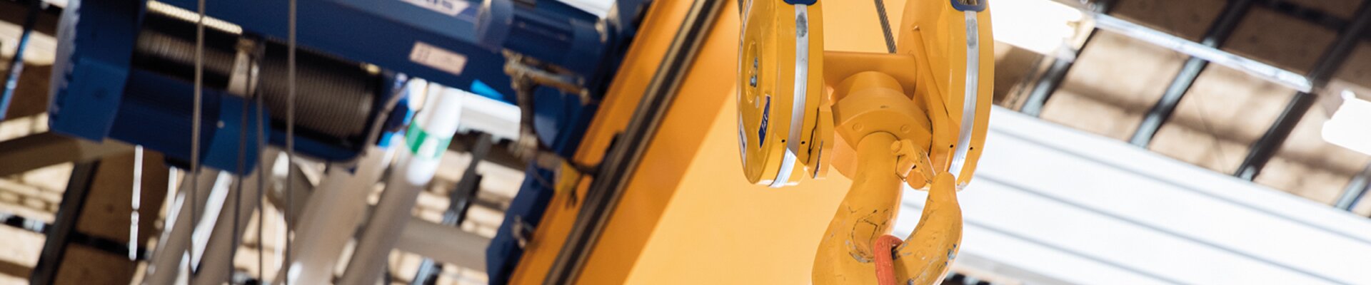 Close-up of double-girder travelling crane with electric wire rope hoist in tandem operation