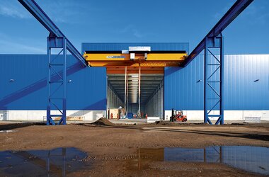 Double girder travelling crane for loading containers between trucks and ships